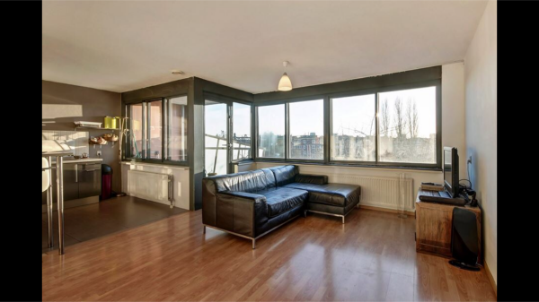 Woonkamer/open keuken richting zuid/westen in hoek balkon